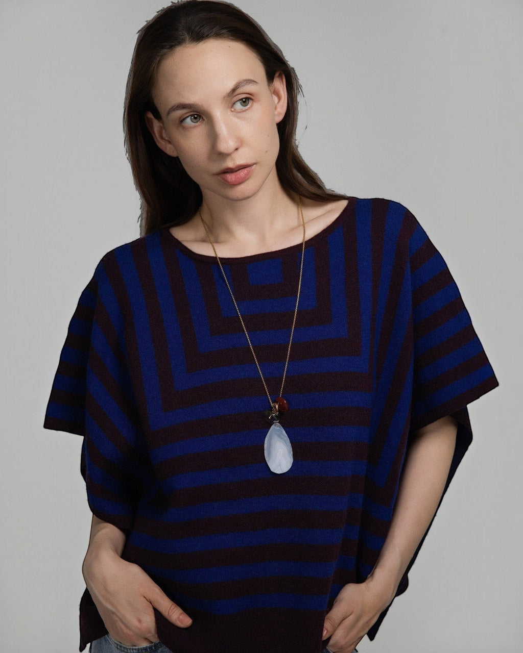Model wearing Elsita Jewelry Glacier Day necklace with white agate, smoky quartz, and red agate on a gold-tone chain.