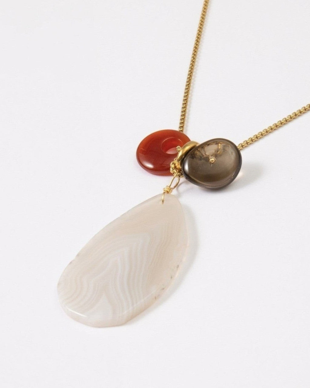 Elsita Jewelry Glacier Day necklace featuring a white agate slice, red agate, and smoky quartz on a gold-tone chain.