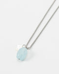 Elsita Jewelry Azul necklace featuring a light blue faceted gemstone and a small white pearl on a silver chain.