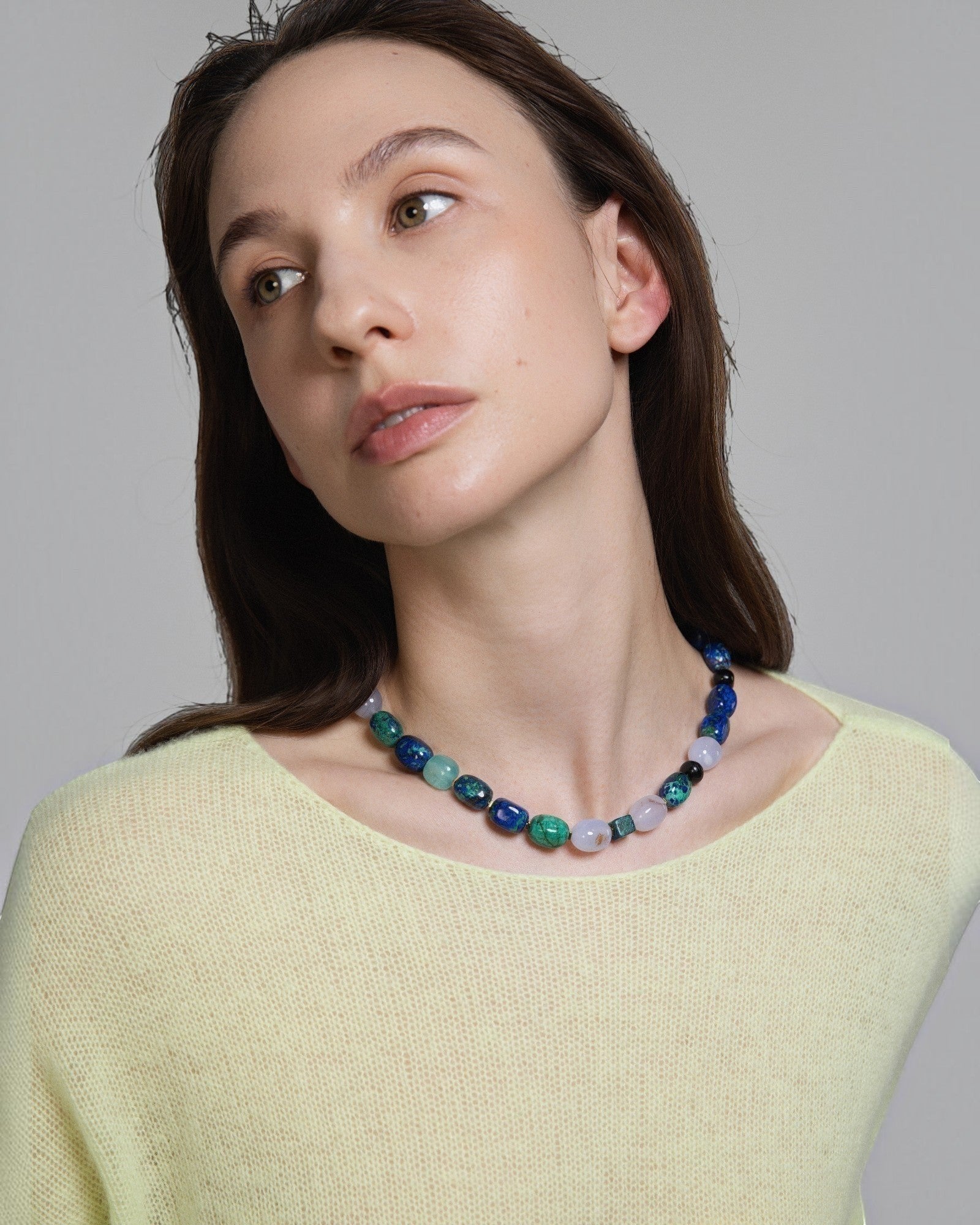 Model wearing Elsita Jewelry Blausee Depth necklace featuring azurite, amazonite, chalcedony, and black tourmaline beads.