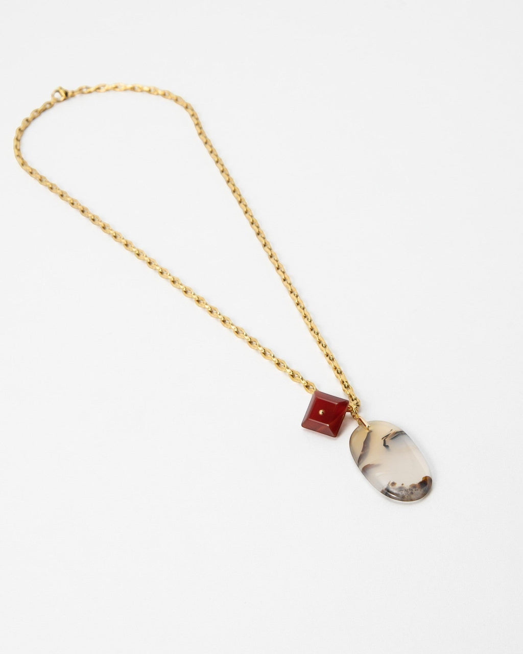 Elsita Jewelry Calligraphy necklace featuring a gold chain, a red square bead, and an oval dendritic agate pendant.
