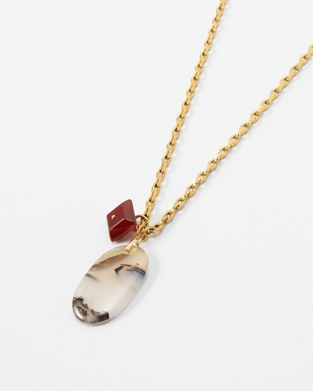 Elsita Jewelry Calligraphy necklace featuring an oval agate pendant and a small red charm on a gold chain