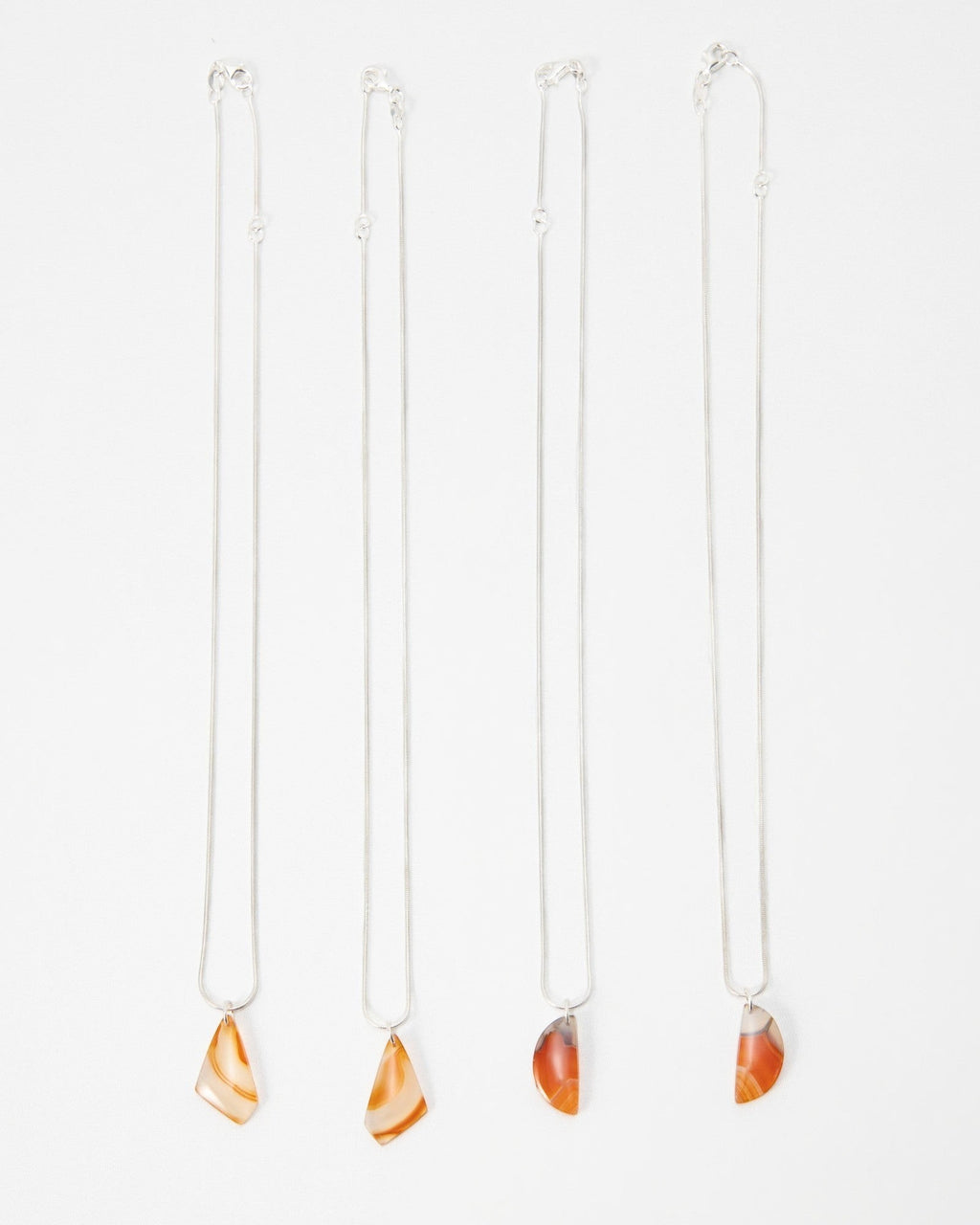 Elsita Jewelry Citrus II necklaces featuring polished orange and red agate pendants on delicate silver chains