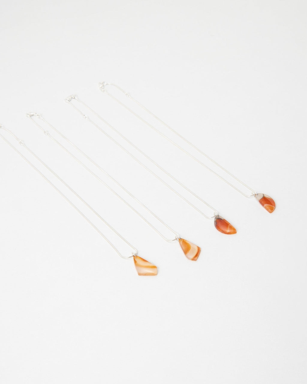 Elsita Jewelry Citrus II necklaces featuring polished orange agate stone pendants on delicate silver chains.