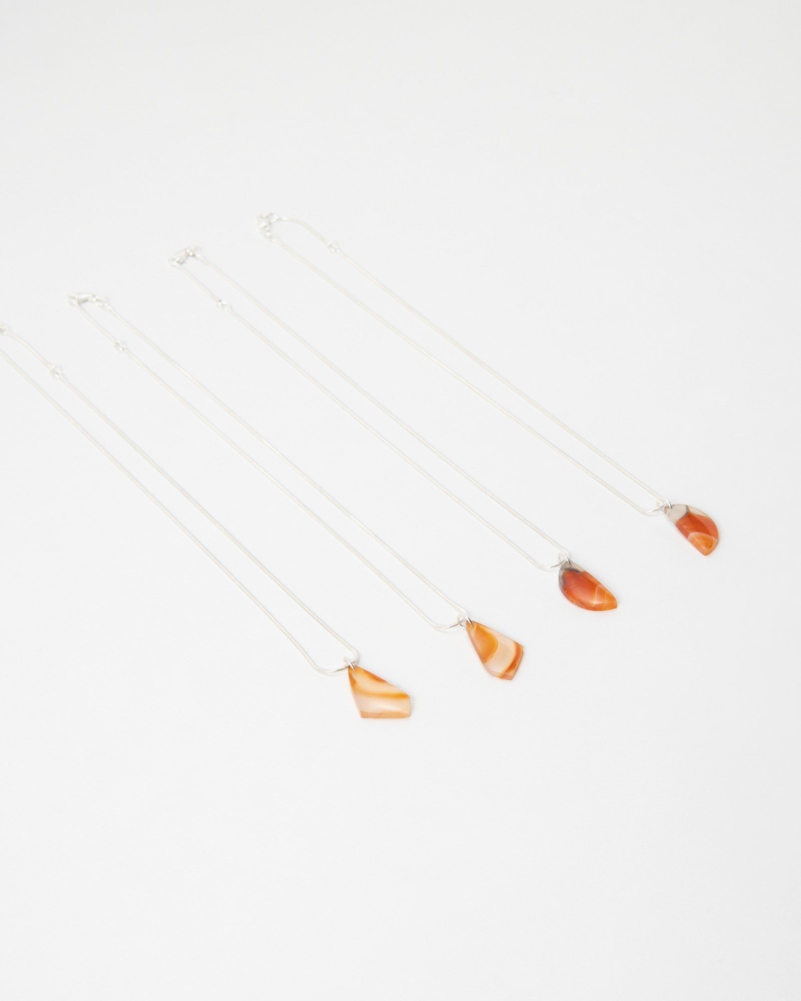 Elsita Jewelry Citrus II necklaces featuring polished orange agate stone pendants on delicate silver chains.