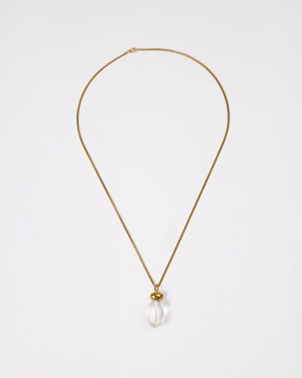 Elsita Jewelry Lustre I necklace featuring a clear quartz pendant on a gold-tone stainless steel chain