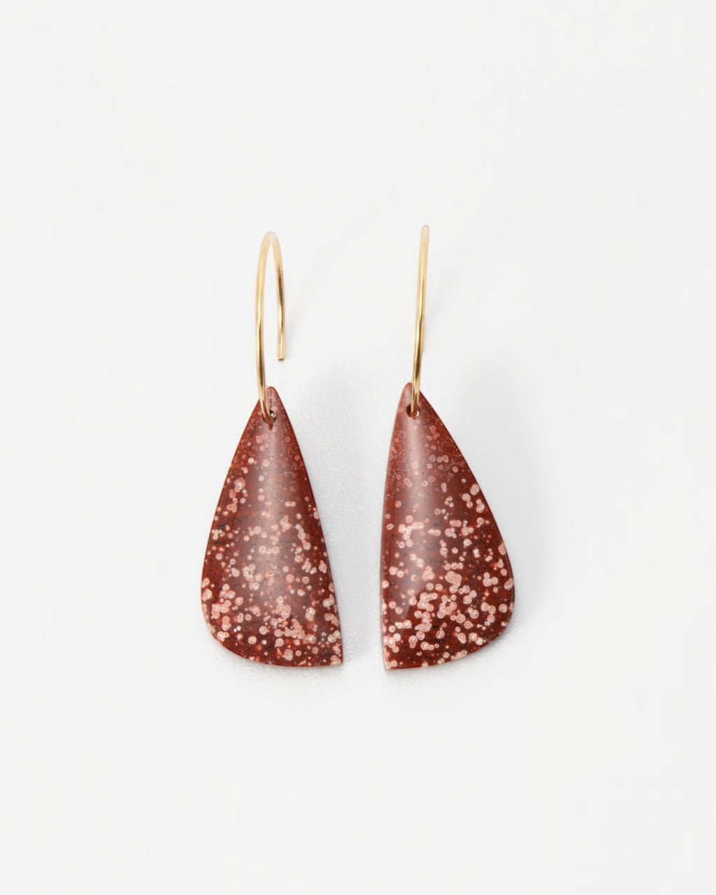 Elsita Jewelry Coral earrings featuring teardrop-shaped terracotta clay pendants with white speckles on gold hoops.