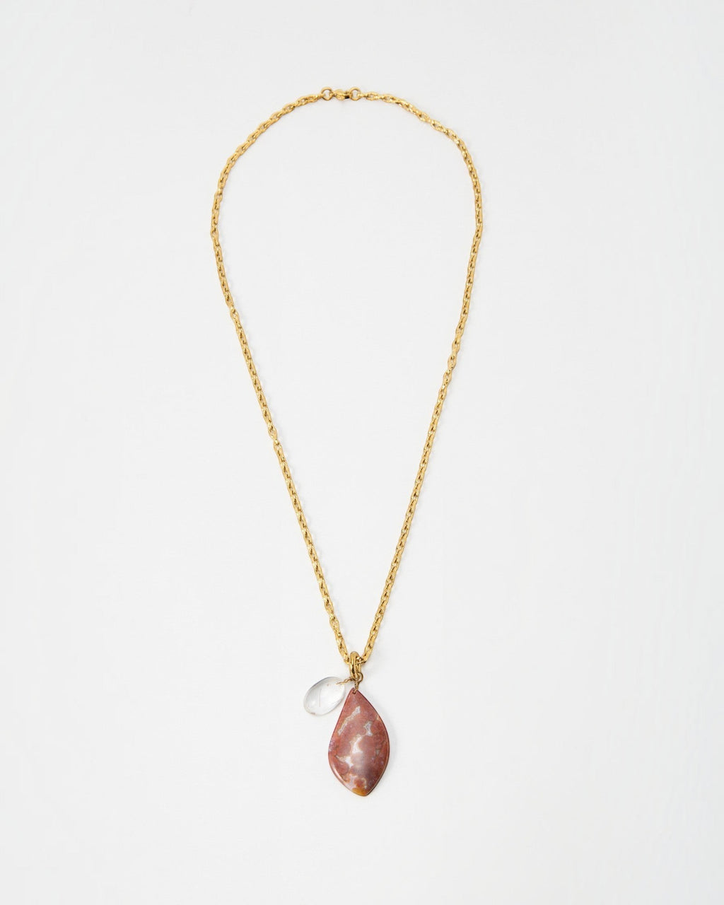 Elsita Jewelry Drift necklace featuring a gold chain with a teardrop-shaped pink stone and a small clear crystal charm.