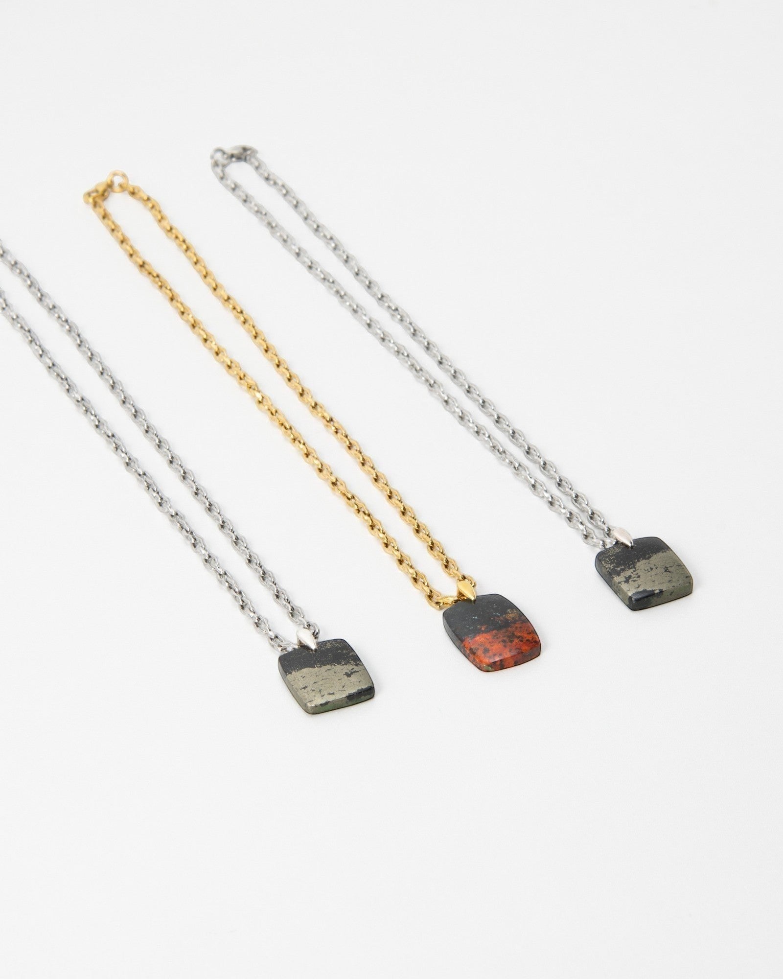 Elsita Jewelry Dune Day necklaces featuring square stone pendants on gold and silver chains against a white background.