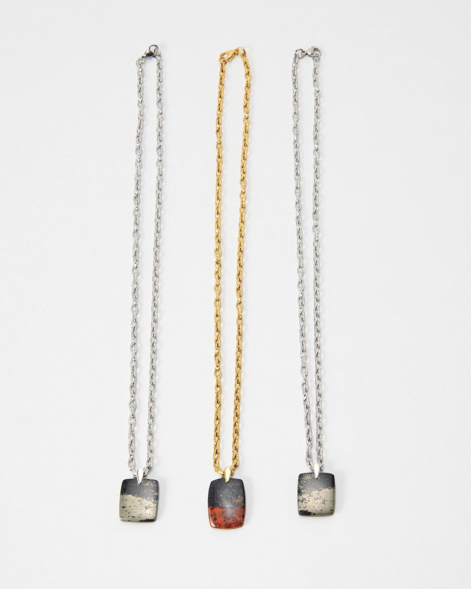 Elsita Jewelry Dune Night necklaces featuring three rectangular stone pendants on gold and silver chains.