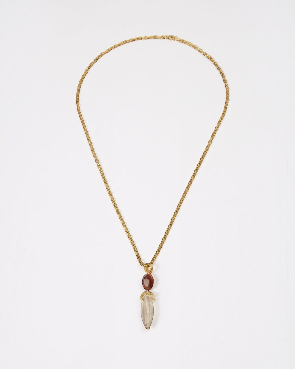 Elsita Jewelry Flame necklace featuring a raw clear quartz pendant and red agate on a textured gold chain.