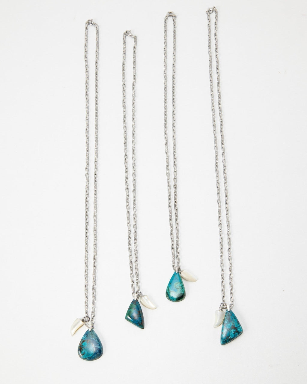 Elsita Jewelry Lagoon III necklaces featuring blue teardrop stones and small white accents on silver chains