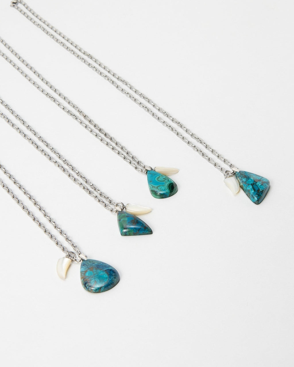 Elsita Jewelry Lagoon III necklaces featuring teal and blue azurite malachite stones with white shell accents on silver chains.
