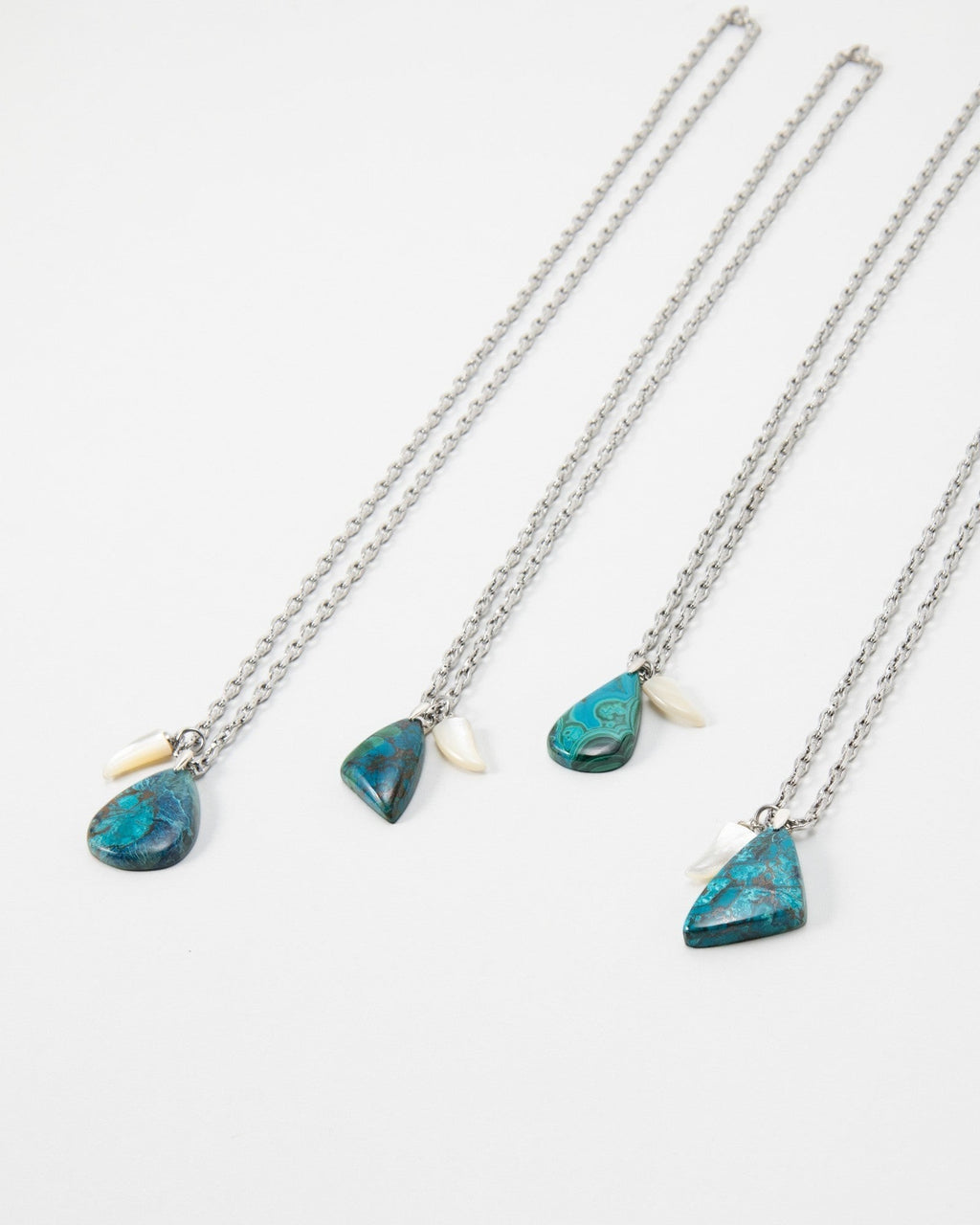 Elsita Jewelry Lagoon IV necklaces featuring blue azurite-malachite pendants and small white shell accents on silver chains