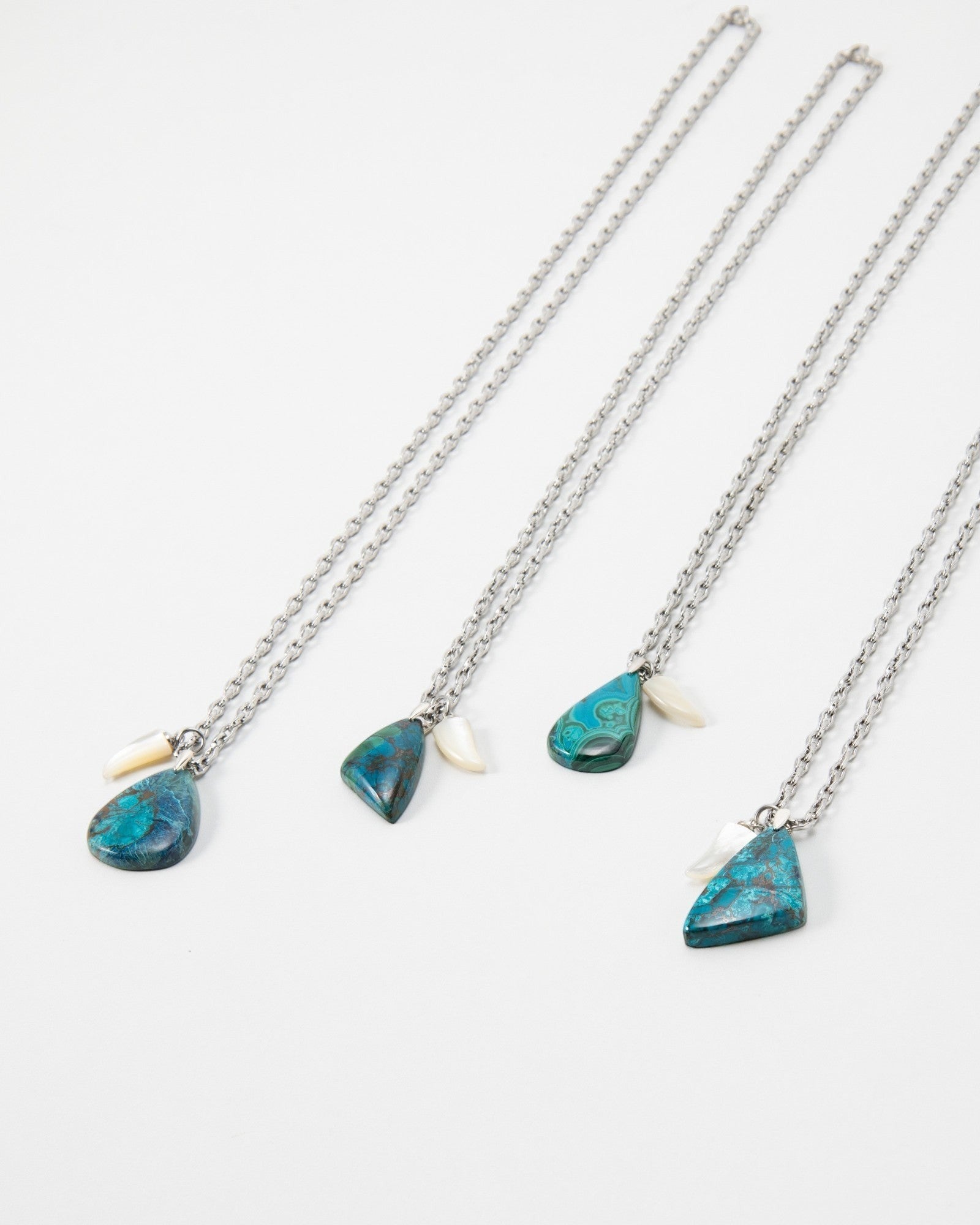 Elsita Jewelry Lagoon IV necklaces featuring blue azurite-malachite pendants and small white shell accents on silver chains
