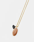 Elsita Jewelry Mist II necklace featuring a delicate gold chain with a black stone and a smooth peach-toned pendant.