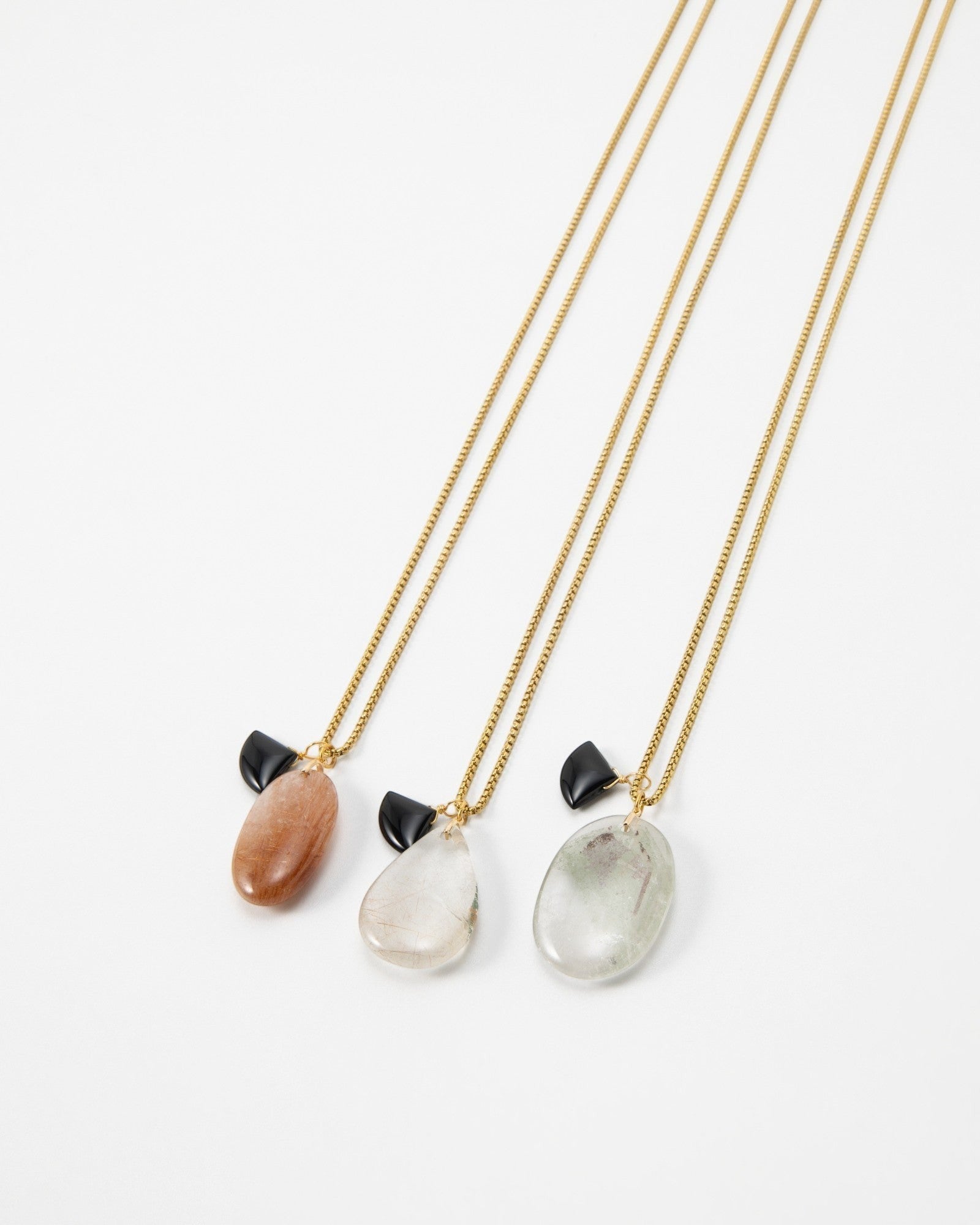 Elsita Jewelry Mist III necklaces featuring gold chains with teardrop-shaped gemstones and small black accents