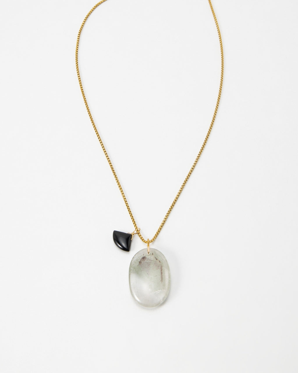 Elsita Jewelry Mist III necklace featuring a large oval translucent stone and a small black charm on a gold chain.