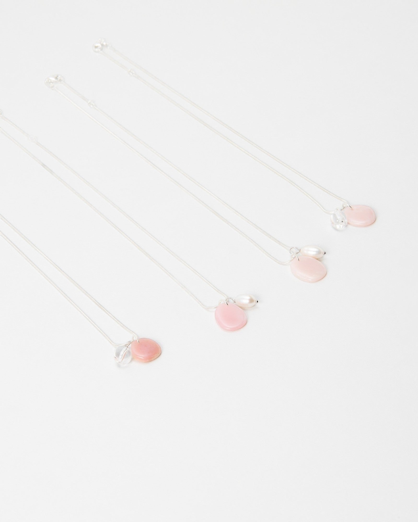 Elsita Jewelry Petal Pearl necklaces featuring delicate pink stone charms and small white pearls on silver chains.