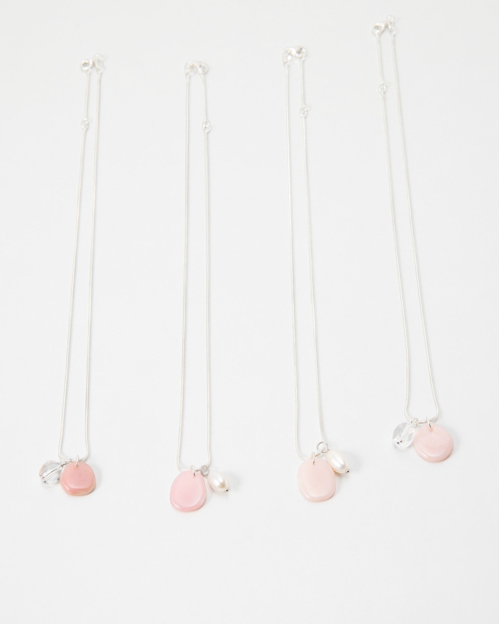 Elsita Jewelry Petal Pearl necklaces featuring delicate pink stone charms and white pearls on silver chains