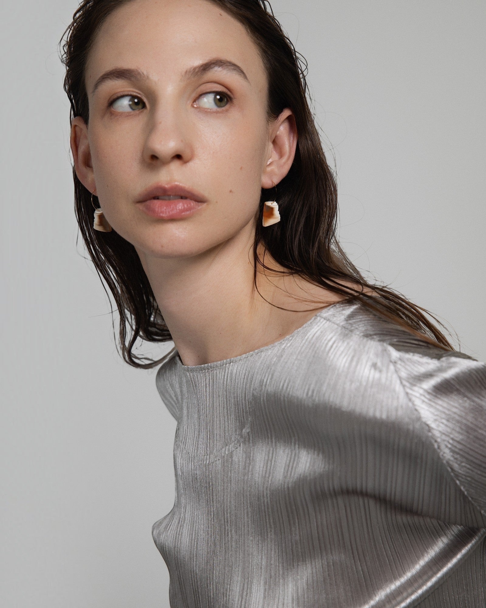 Elsita Jewelry Wild 2 raw Indonesian agate slice earrings on 14K gold-filled hoops worn by a model.