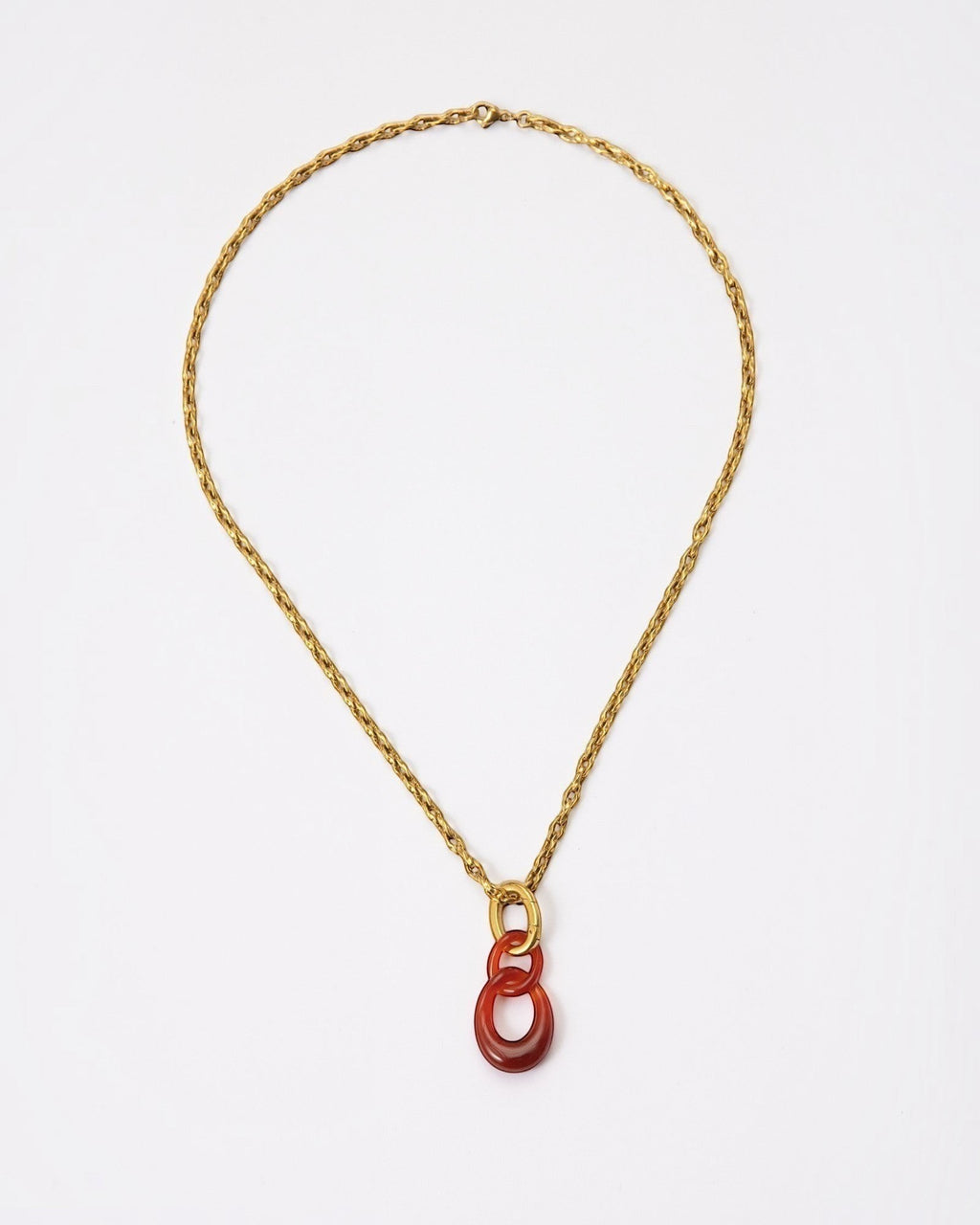 Elsita Jewelry Link Red necklace featuring hand-carved red agate interlocked chain pendant on a gold-tone metal chain.