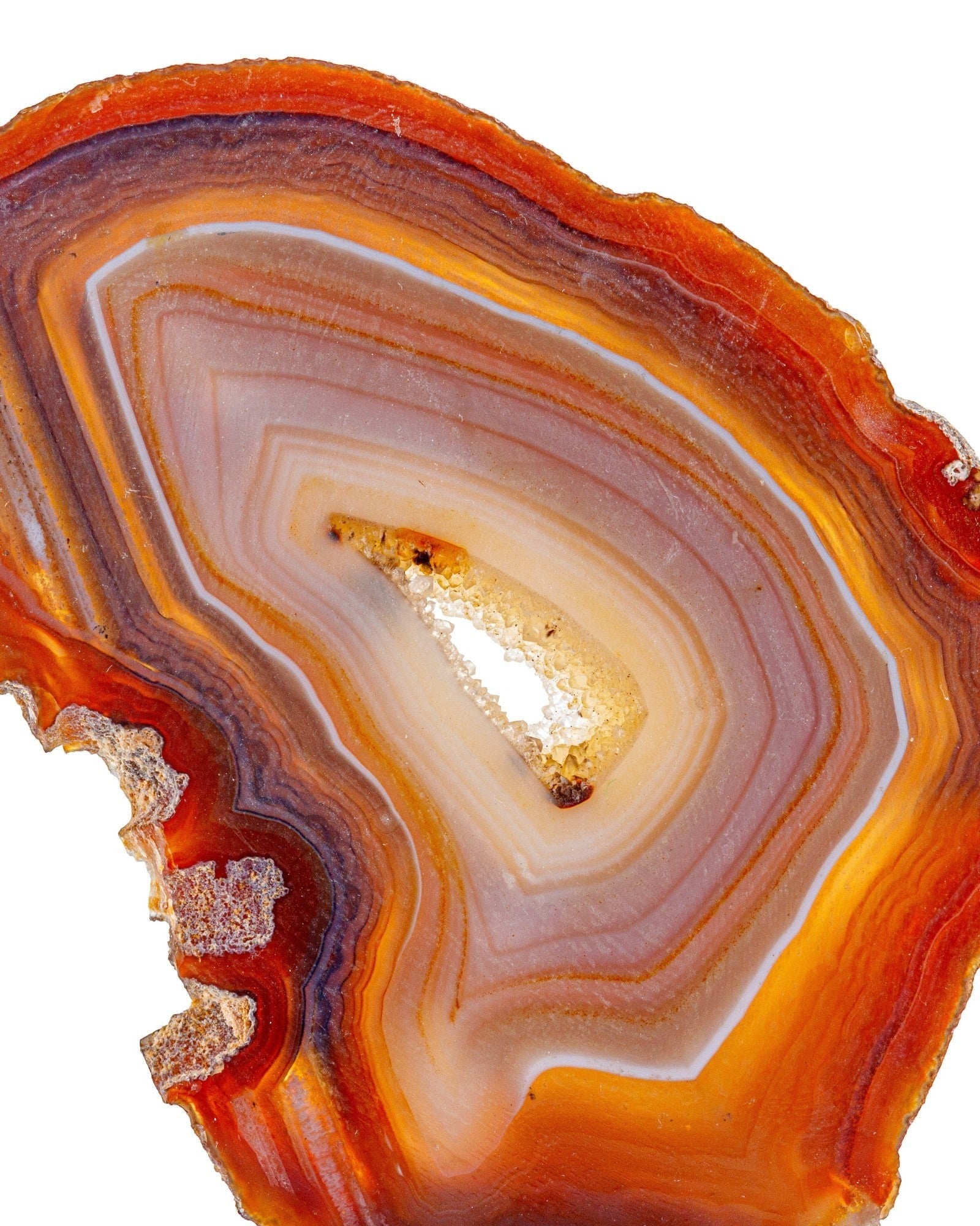 Elsita Jewelry red agate slice with natural orange and brown banding and a central clear quartz crystal geode cavity.