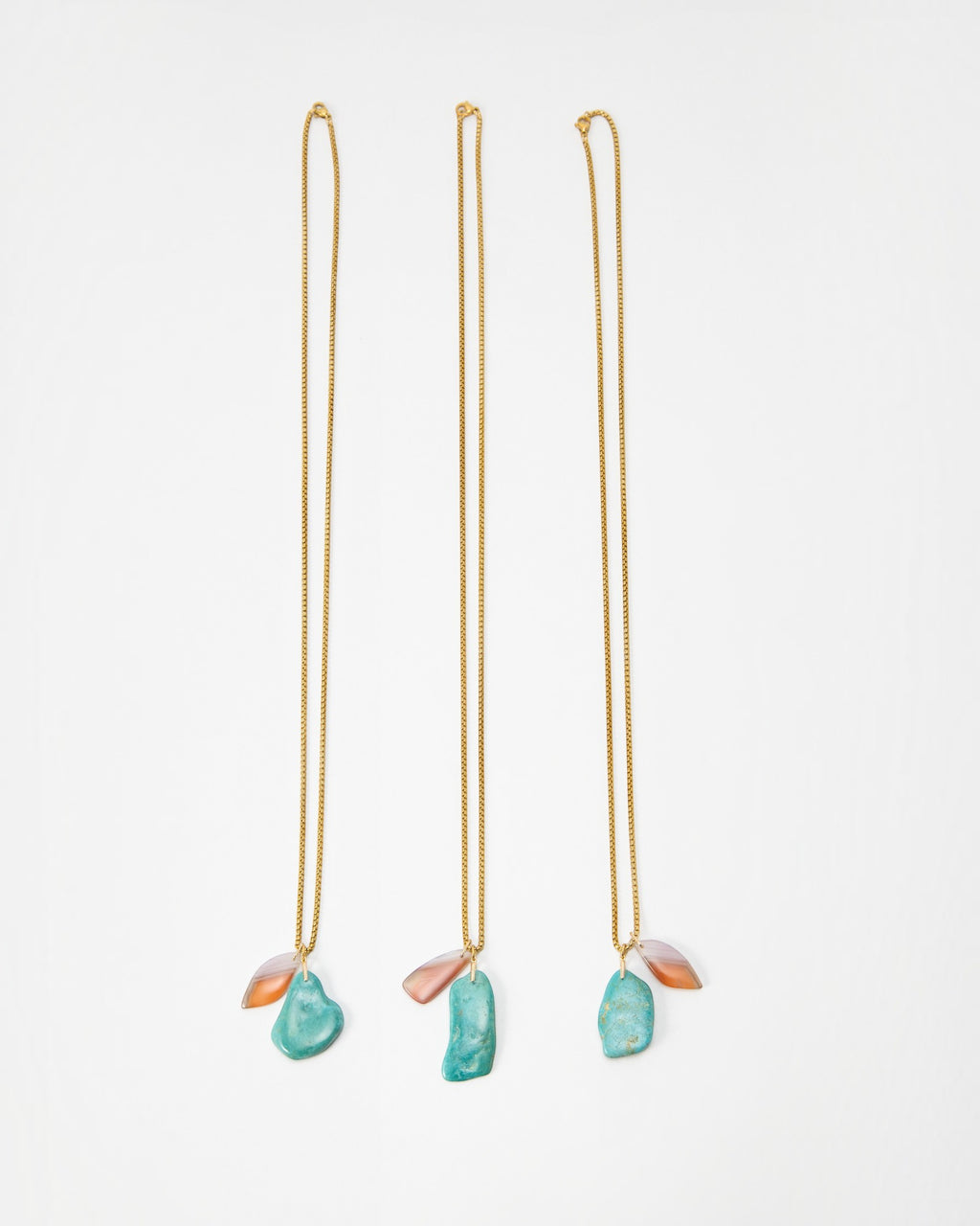 Elsita Jewelry Rusty I necklaces featuring gold chains with dangling turquoise and orange stone pendants