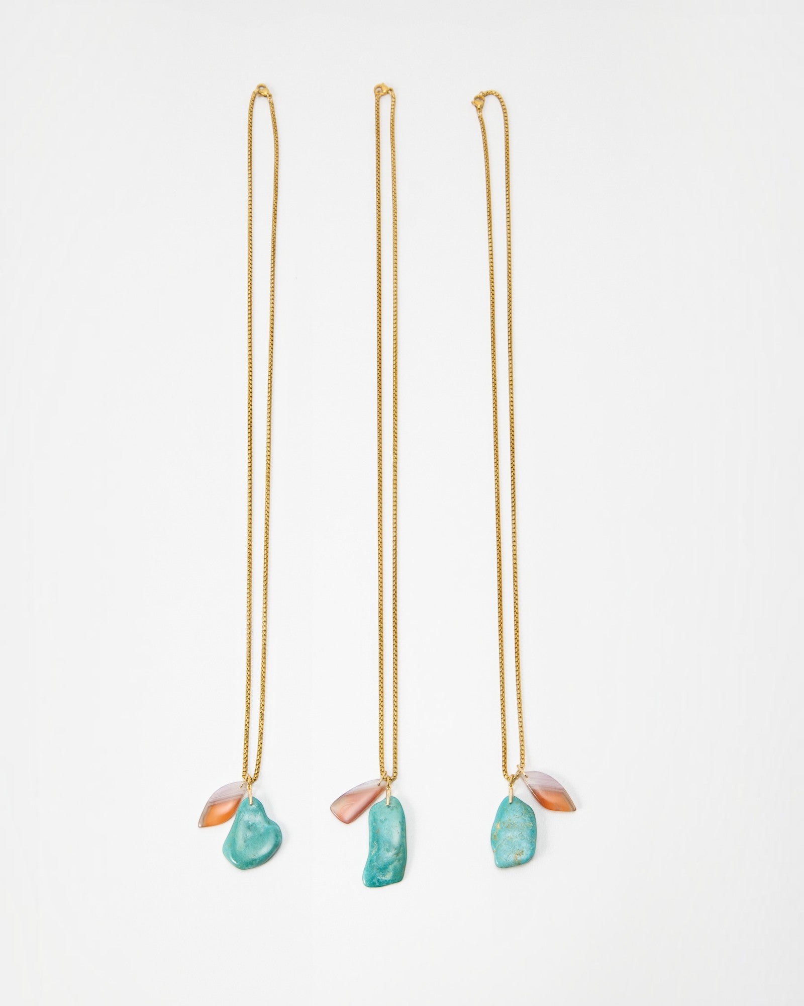 Elsita Jewelry Rusty I necklaces featuring gold chains with dangling turquoise and orange stone pendants