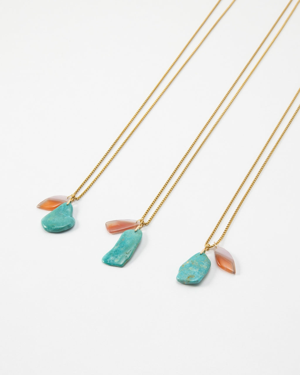 Elsita Jewelry Rusty I necklaces featuring raw turquoise and translucent orange stone pendants on gold chains
