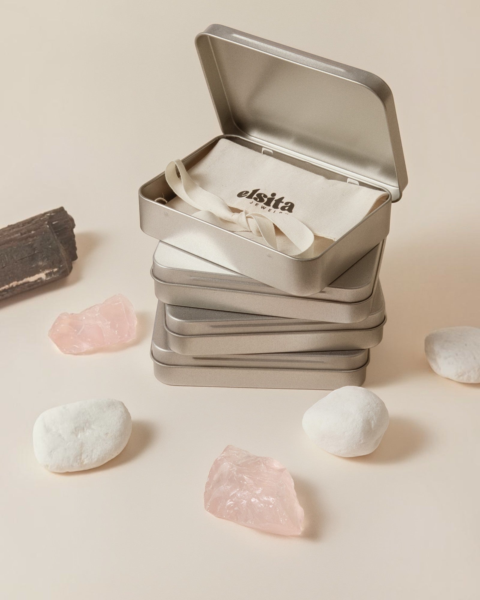 Elsita Jewelry Wild 14 agate earrings packaged in a branded metal tin with raw mineral stones on a neutral background
