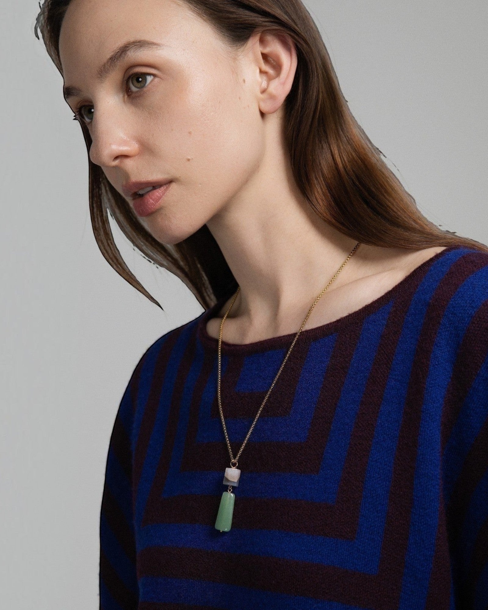 Model wearing an Elsita Jewelry Wildbach pendant necklace featuring Uruguayan agate and green aventurine on a gold chain.